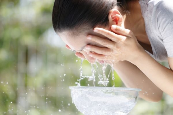ぬるま湯で洗顔をする女性